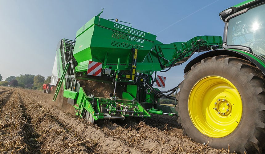 Dieser Kartoffelroder fährt neben dem Traktor, so dass die Niederdruck-Breitreifen des Traktors nicht gewechselt werden müssen